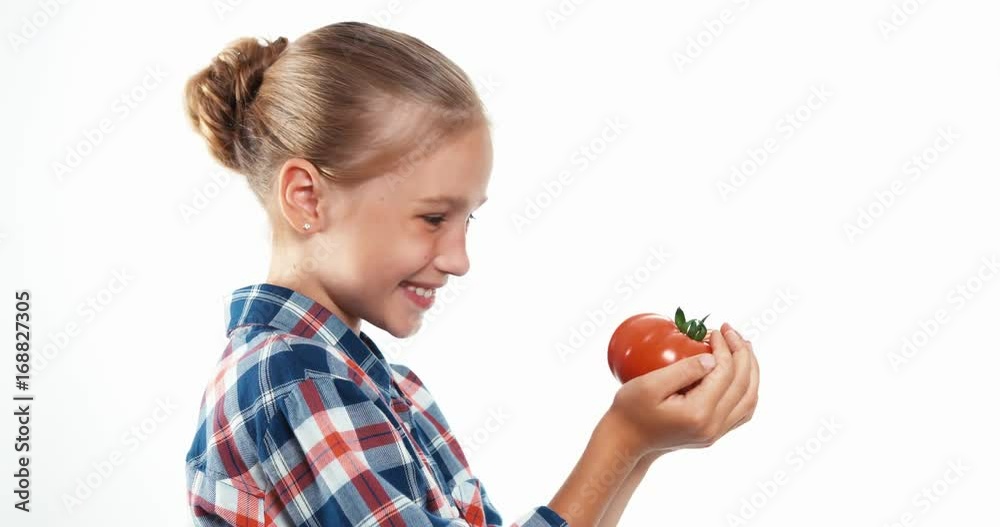 Closeup portrait girl child eating big ripe tomato isolated on white Closeup portrait girl child eating big ripe tomato isolated on white