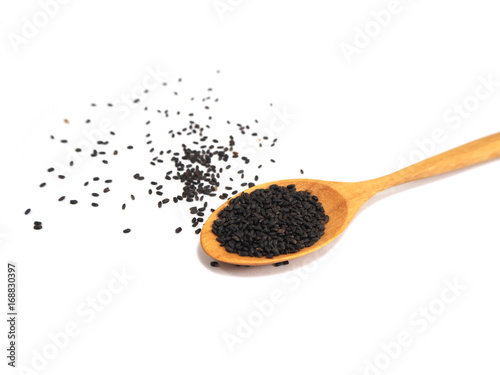 basil seeds on wooden spoon on white background