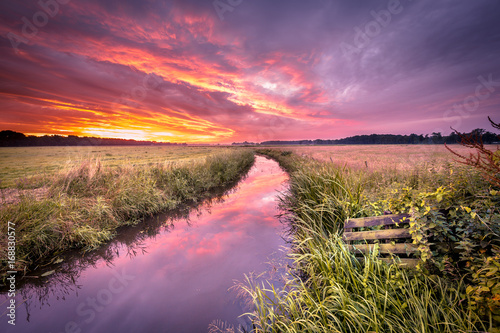 Warm indian summer sunrise over lowland river in vintage colors photo