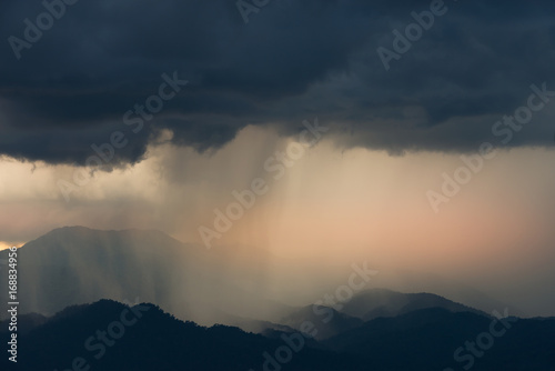 Monsoon in tropical rain forest,.heavy raining in mountain range at sunset..Keep fighting through the barrier and do not give up,there’s light and hope at the end,positive thinking concept.