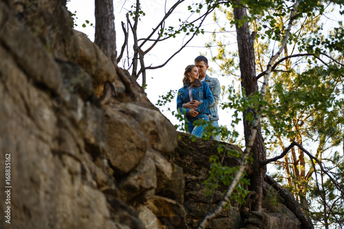 Two young people standing on a rock and holding hands © Angelov