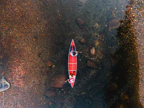 Overhead view of man and woman travelling in boat along the river