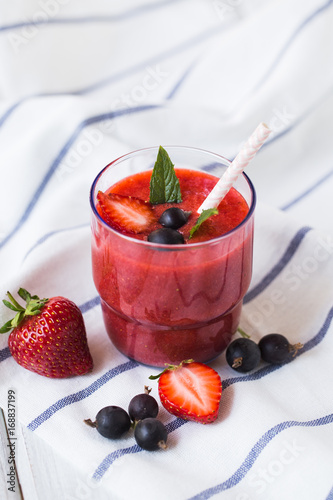 Smoothies of black currant and strawberries with yogurt on a white wooden table. photo