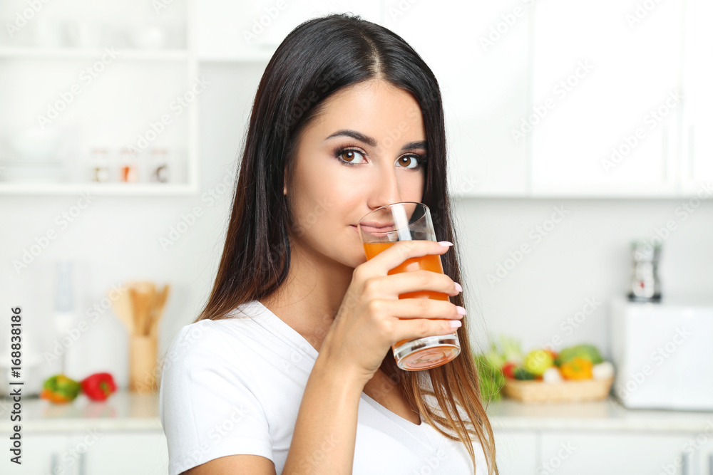 Beautiful young woman drinking juice in the kitchen Beautiful young woman drinking juice in the kitchen