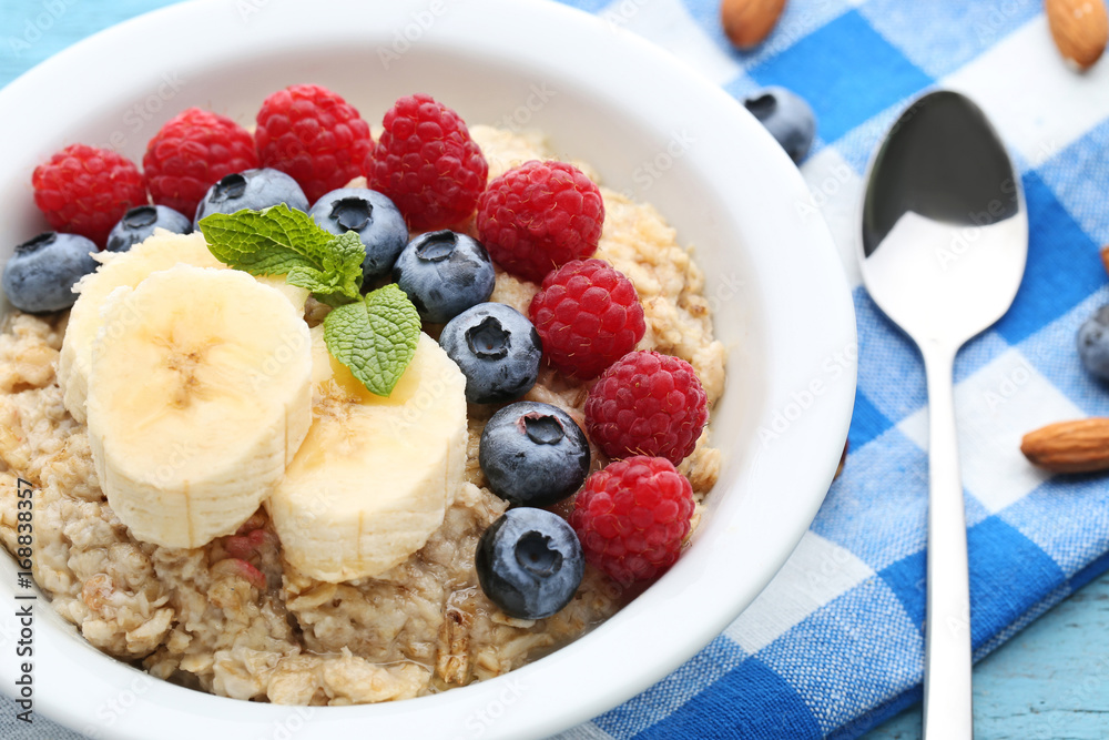 Oatmeal in plate with berries on wooden table