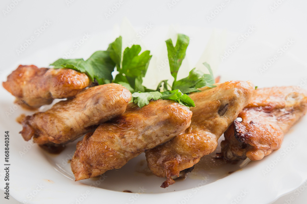 chicken wings with greens on the plate