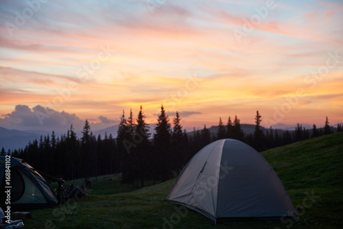Shot of a camping site with tents during beautiful sunset with fiery colorful sky on the background nature peace travel tourism activity lifestyle