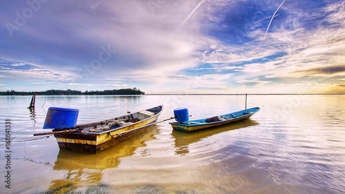 A fisherman boat at seashore with amazing sunrise at Jubakar Pantai, Tumpat, Kelantan, Malaysia. photo