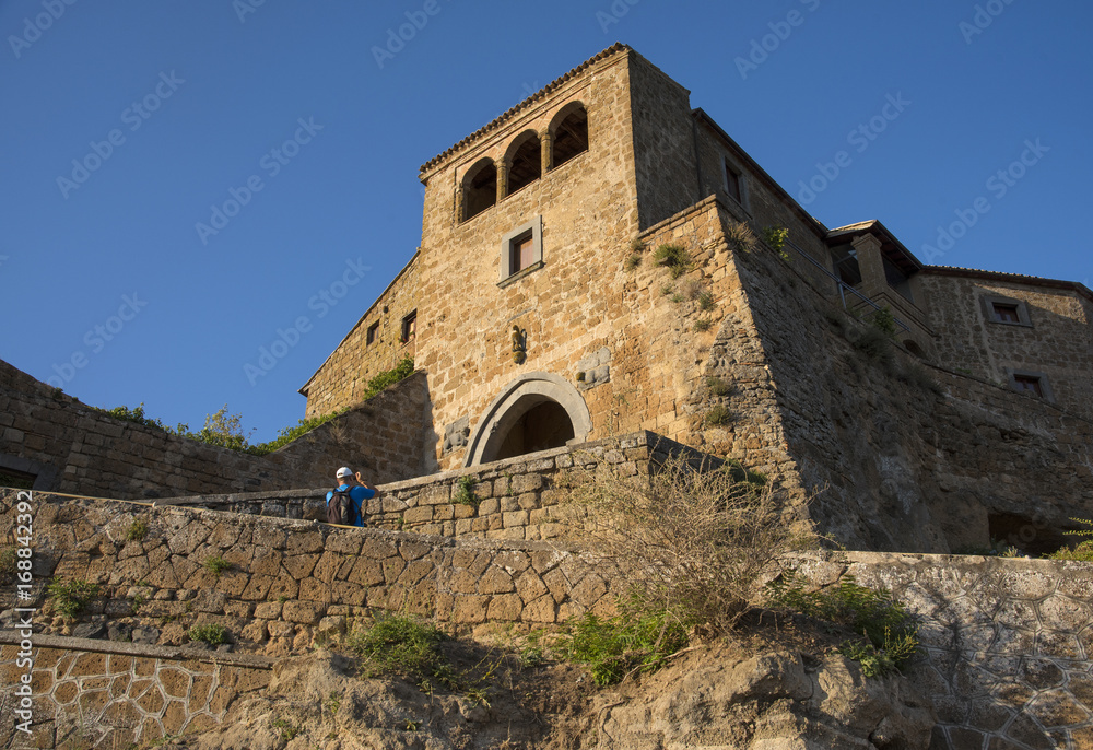 CIVITA DI BAGNOREGIO, ITALY - JULY 2017- Tourist take photos in a old town during Sunset