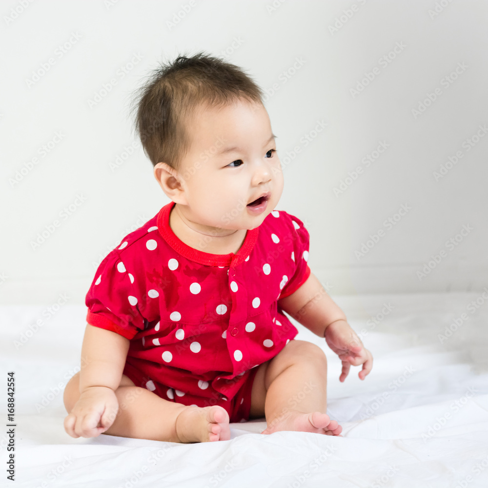Portrait of adorable baby sitting on a white floor and smiling with copyspace Portrait of adorable baby sitting on a white floor and smiling with copyspace