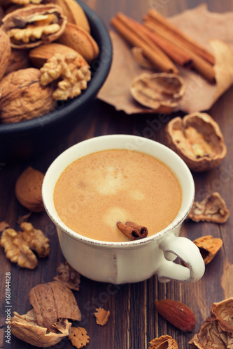 a cup of coffee and nuts on wooden background © Natalia Mylova