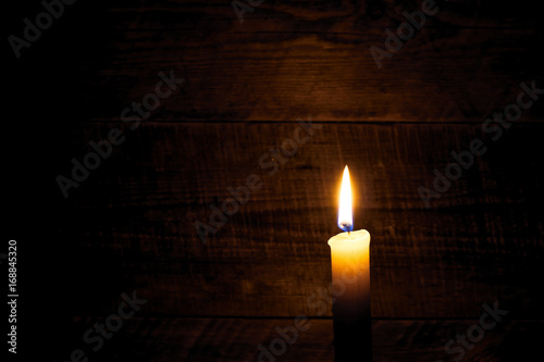 one wax candle on old wooden background
