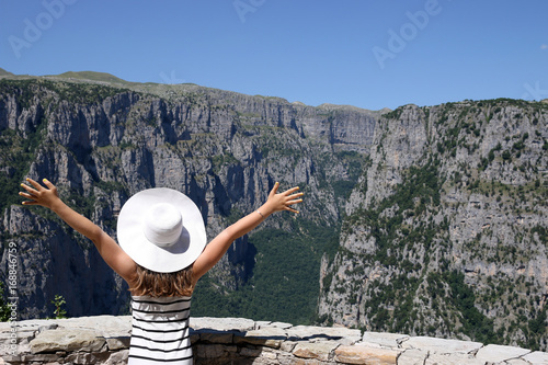 little girl with hands up on the viewpoint Vikos gorge Greece