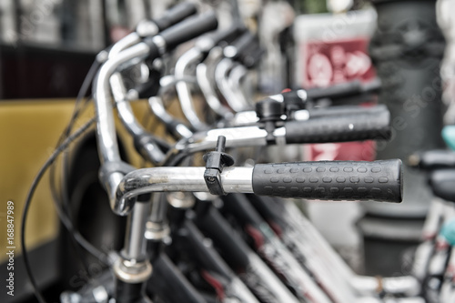 Bicycle handlebars or metallic steering wheels in row in Berlin