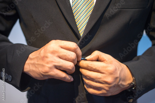 Wedding men's groom hands in black suite button up for wedding preparation