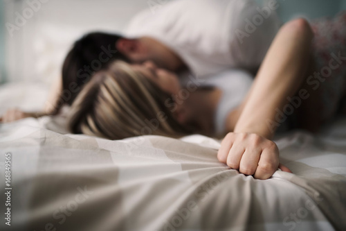 Canvas Print Beautiful couple being romantic and passionate in bed