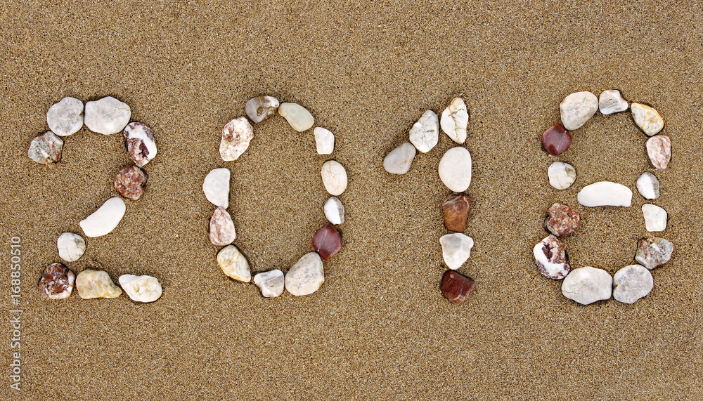 Pebble New Year 2018 number on wet sandy beach. New Year 2018 concept. Pebble New Year 2018 number on wet sandy beach. New Year 2018 concept.