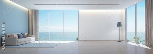 Fotografia Sea view living room with wooden floor and empty white wall background in luxury