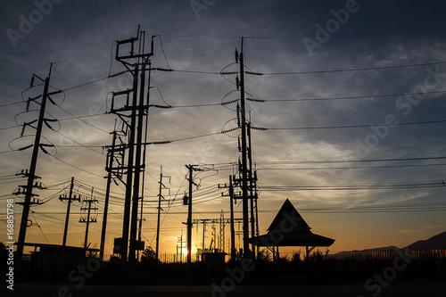 Silhouette of electricity posts during golden sunset