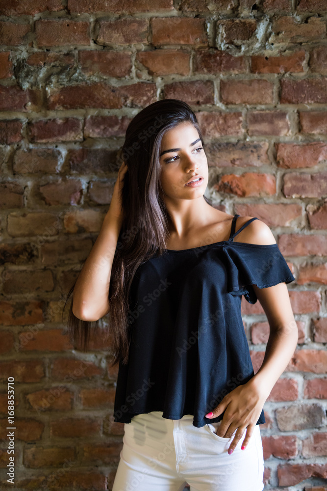 Young beautiful happy woman in casual clothes against brick wall Young beautiful happy woman in casual clothes against brick wall