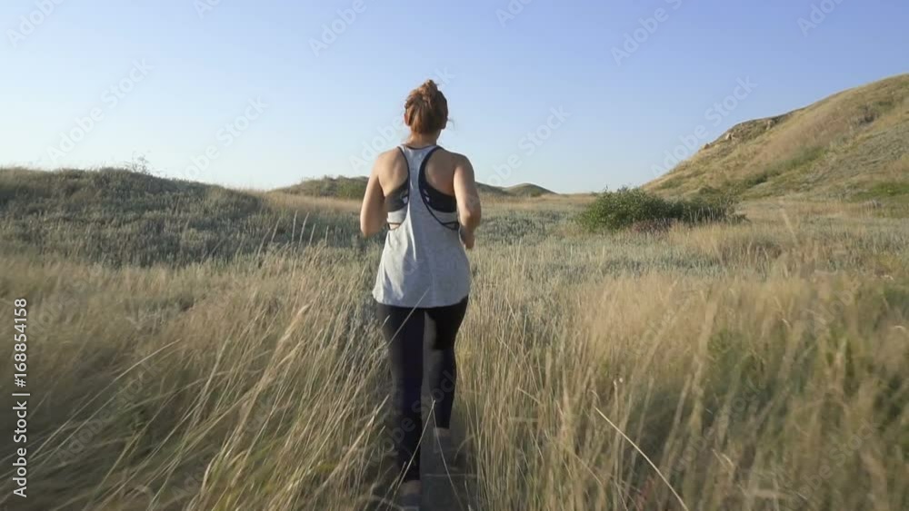 Beautiful girl doing morning jogging at sunrise in the field. outdoors fitness Beautiful girl doing morning jogging at sunrise in the field. outdoors fitness