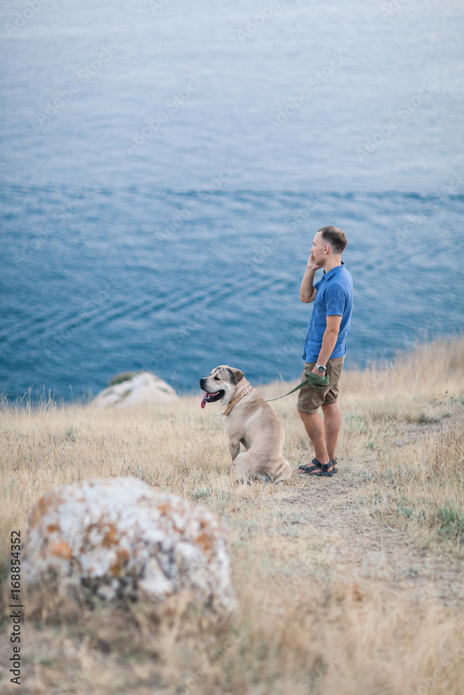 Young caucasian male walking with dog during sunrise Young caucasian male walking with dog during sunrise