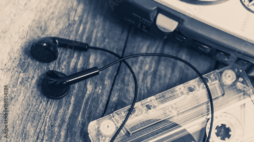 Vintage walkman cassette player with earbuds and tape cassette, retro style toned image