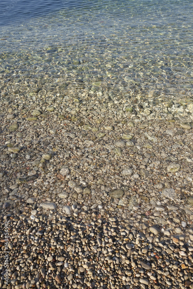 Beach with soft waves and small stones, Blue sea in summer, Beach backgrounds Beach with soft waves and small stones, Blue sea in summer, Beach backgrounds