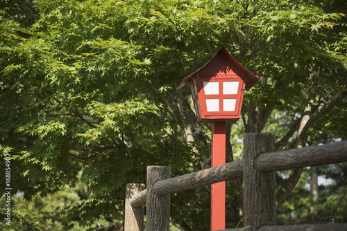 Lamp in japanese style at shrine or temple with maple leaves background. © NaMong Productions