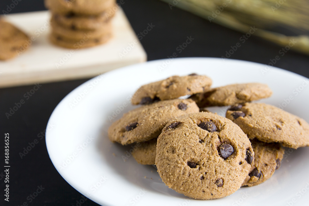 Chocolate Chip Cookies on chopping wood and white plate Chocolate Chip Cookies on chopping wood and white plate