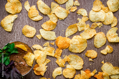 Potato chips with dipping sauce on a wooden table. Unhealthy food on a wooden background.