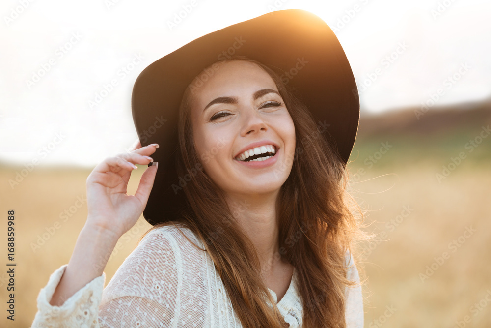 Obraz premium Beautiful young happy woman standing in the field