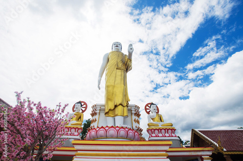 buddha statue with blue sky at Wat Phra That Doi Kham, Chiang Mai, Thailand. photo