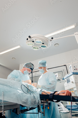 Patient lying on the bed restraint the arm with cotton on operating table