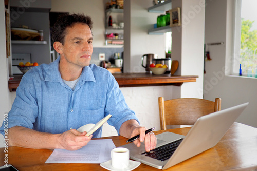Man using his laptop in home office.