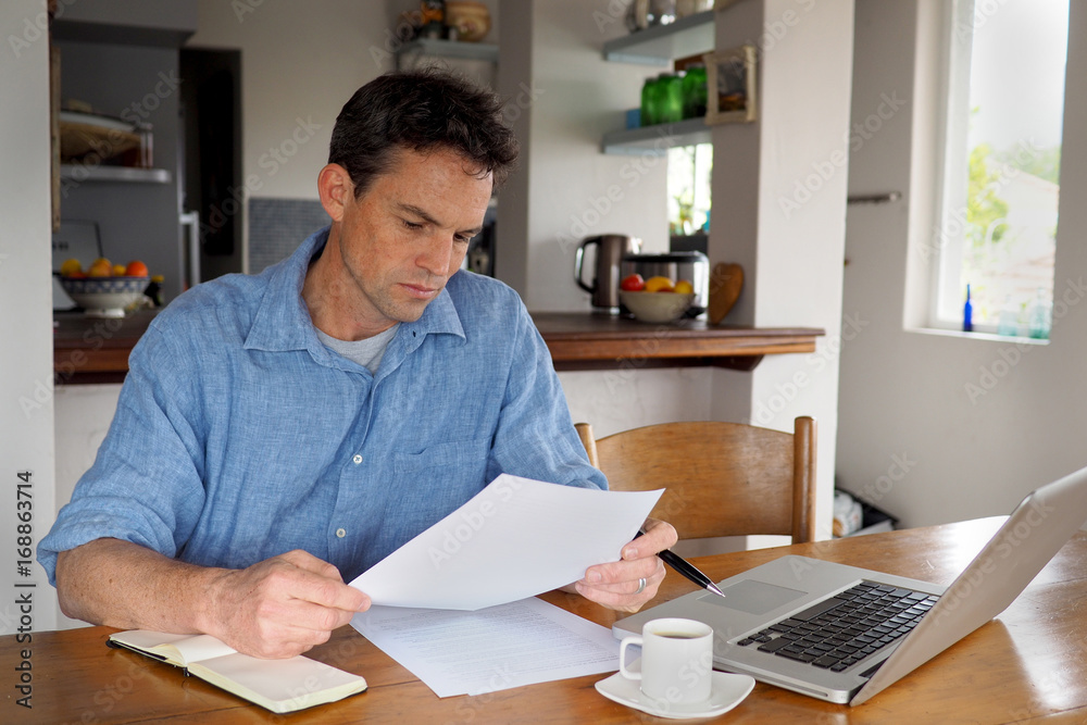 Man reading a document in home office environment