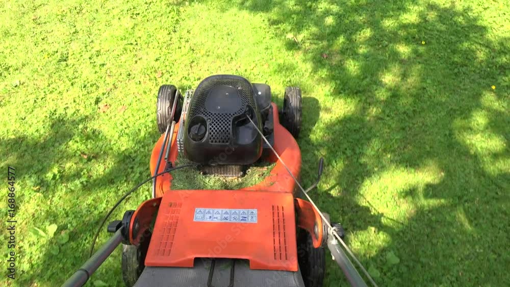 Barefeet unshod gardener man walk pushing lawn mower cutting grass. 4K Barefeet unshod gardener man walk pushing lawn mower cutting grass. 4K