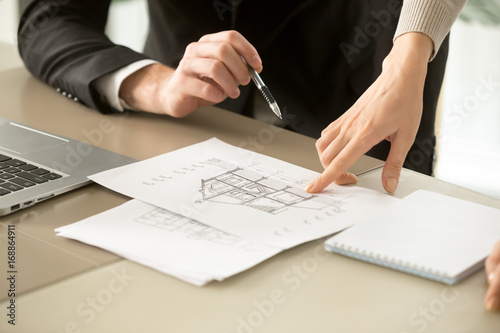 Close up view of two-story house construction project, architects discuss home building architectural plan, agents determine price of real estate object for sale, property value estimation appraisal photo