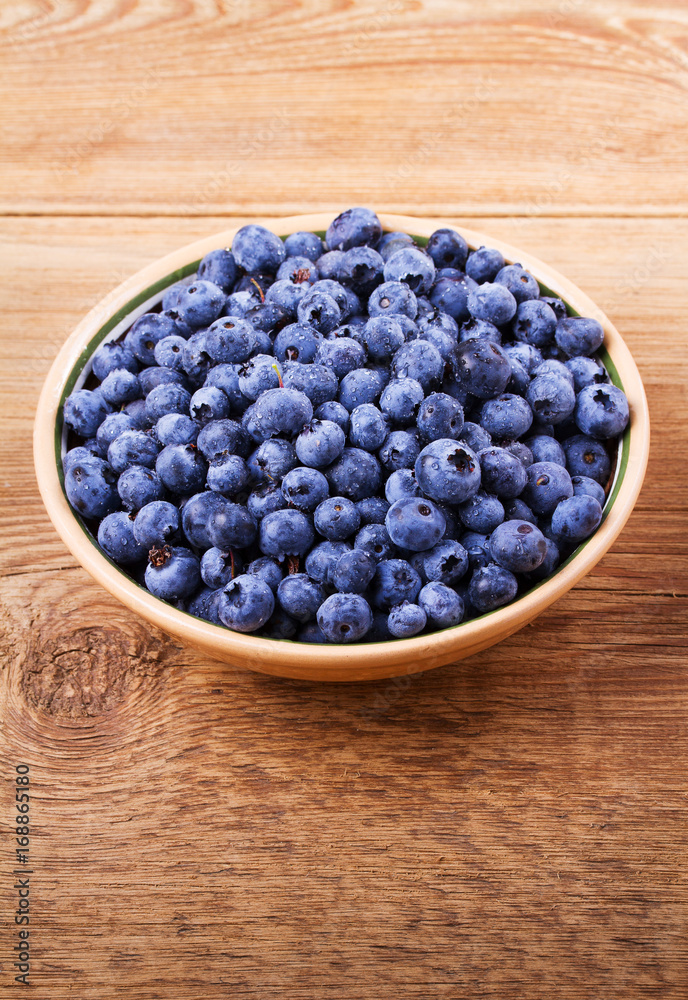 Blueberries in clay bowl. Freshly picked berries on rustic background. Blueberry antioxidant superfood, concept for healthy eating Blueberries in clay bowl. Freshly picked berries on rustic background. Blueberry antioxidant superfood, concept for healthy eating