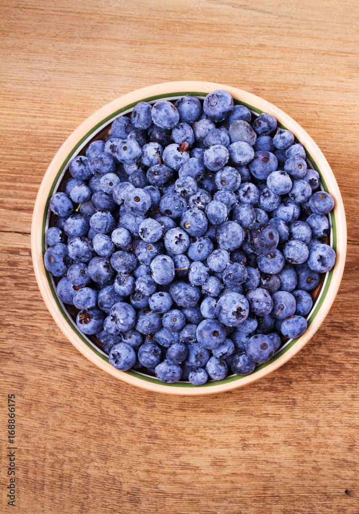 Blueberries in clay bowl. Freshly picked berries on rustic background. Blueberry antioxidant superfood, concept for healthy eating. View from above, top studio shot Blueberries in clay bowl. Freshly picked berries on rustic background. Blueberry antioxidant superfood, concept for healthy eating. View from above, top studio shot