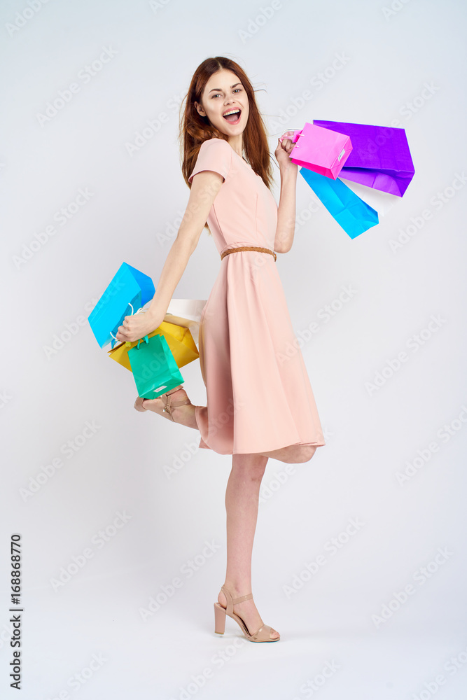 Young woman on a white background holds a lot of packages, shopping, full-length, joy, shopaholic