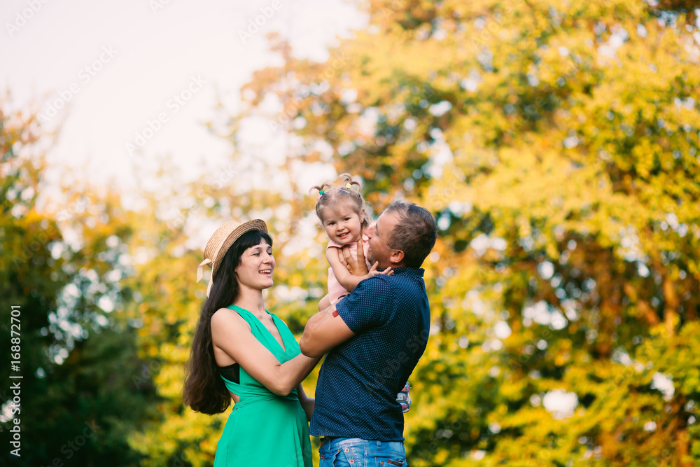 happy family concept - father, mother and child daughter having fun and playing in nature.