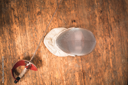 fencing mask and rapier on floor. photo