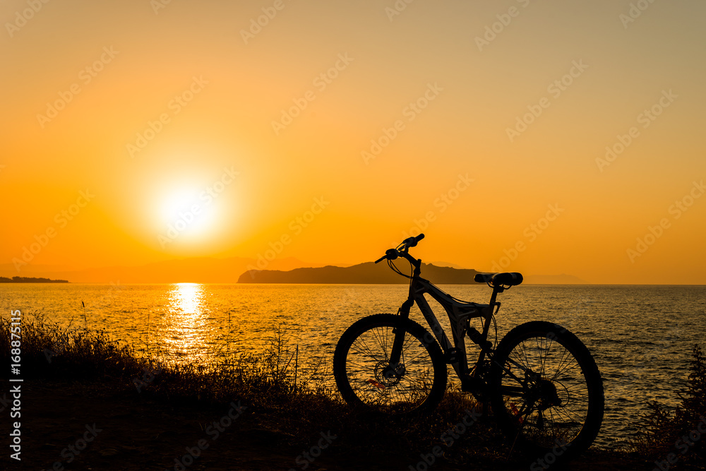 Fototapeta premium Picture of bicycle on the sunset sea overview