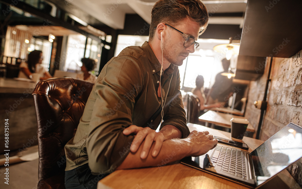 Young man sitting at startup using laptop Young man sitting at startup using laptop