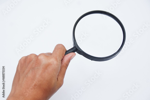 Hand Holding Magnifying Glass Over White Background