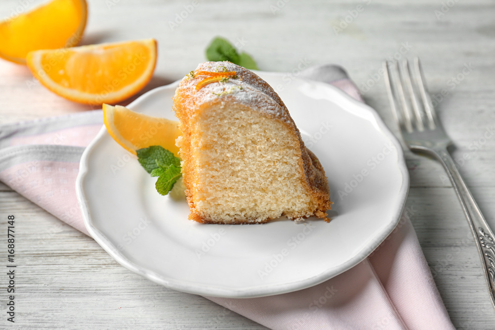 Plate with delicious citrus cake on wooden table