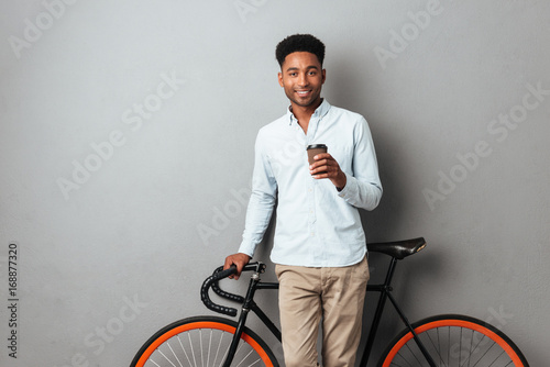 Happy young african man drinking coffee.