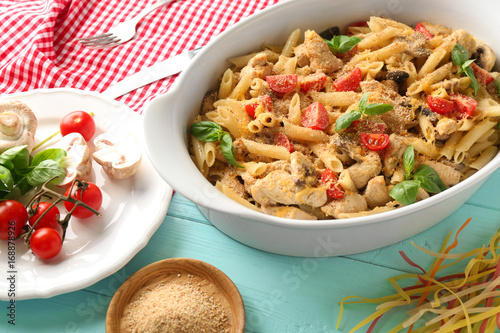 Baking dish with delicious turkey tetrazzini and ingredients on table photo