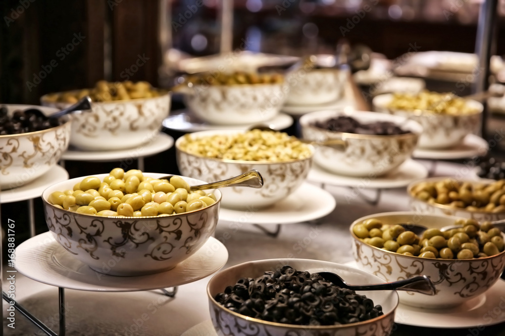 Different kinds of olives in bowls on table at buffet Different kinds of olives in bowls on table at buffet